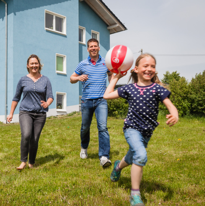 Thüringer Familienbaudarlehen (Familie spielt vor dem Haus)